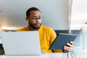 african american businessman with laptop and tablet pc computer at office