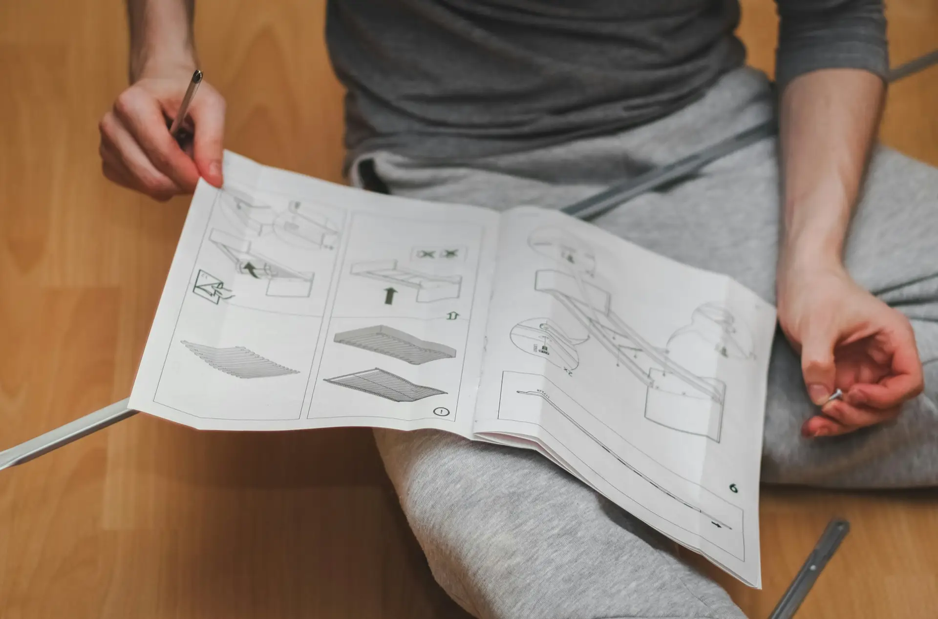 Caucasian young man reads book instructions for assembling a bed